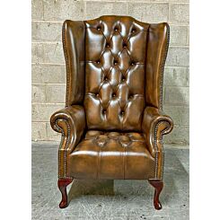 High back Chesterfield wing chair in antique tan leathe, fully buttoned