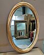 Trendy antiek goud omrande spiegel met facet geslepen glas.